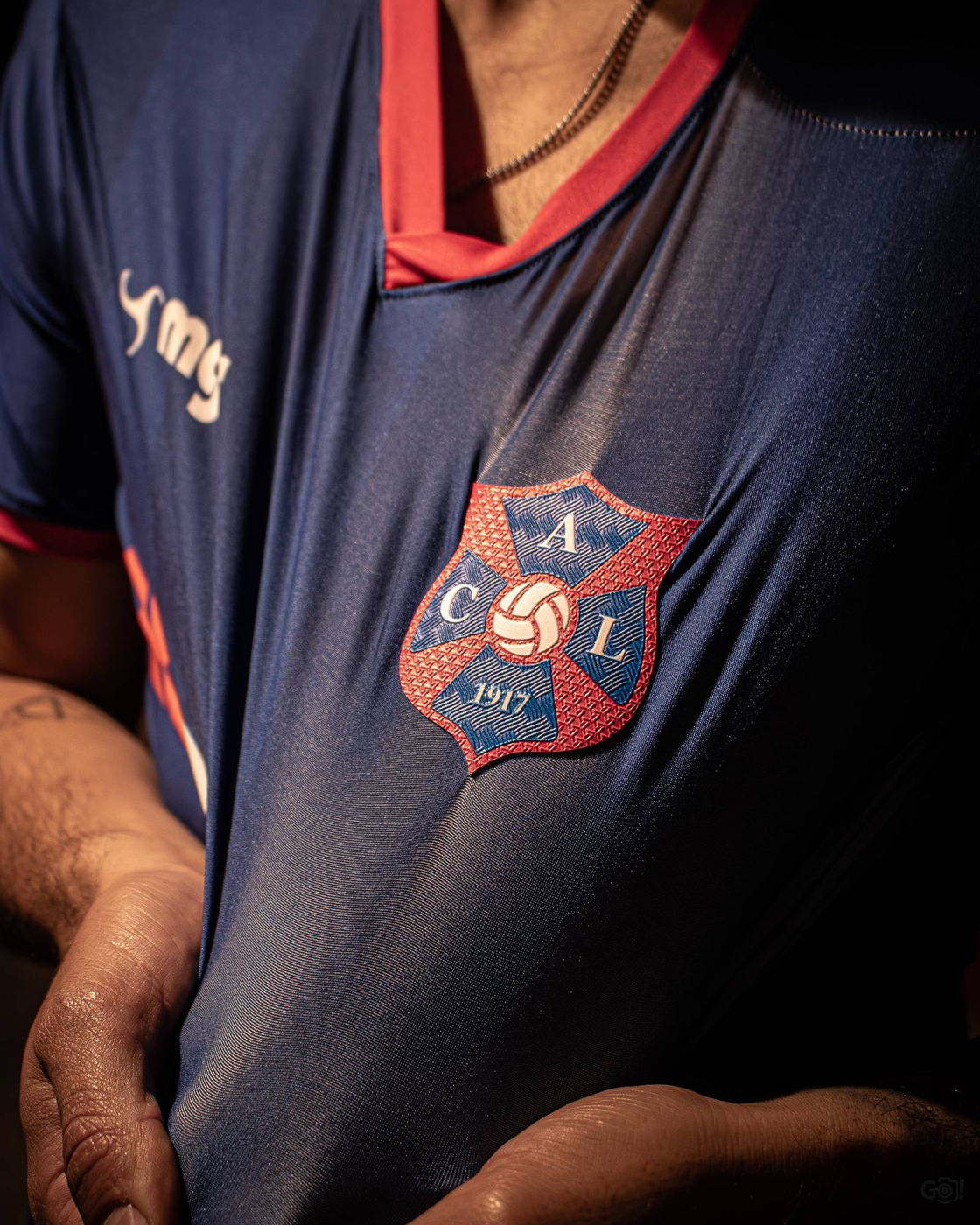 El escudo de Lito bordado en la camiseta de juego